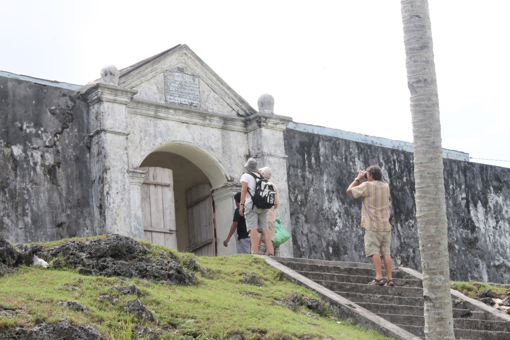 Reizigers bij de ingang van Fort Belgica op de Molukken tijdens de groepsrondreis Kalimantan, Sulawesi & Molukken.