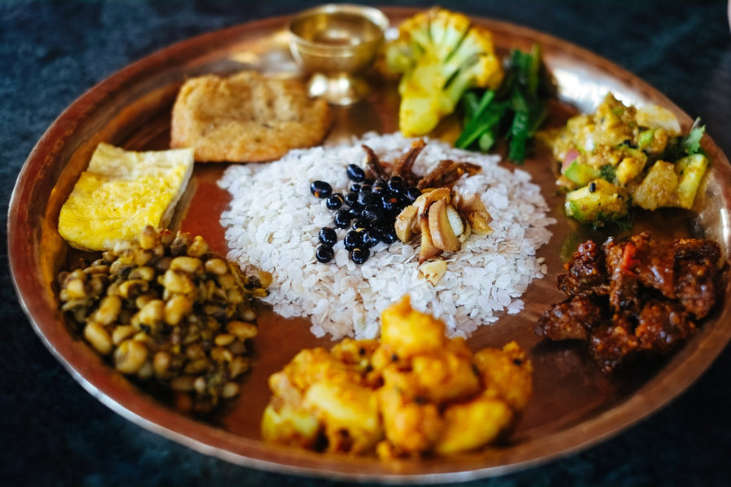 Nepalese dal bhat: rijst met groente- en currygerechten op een metalen bord.