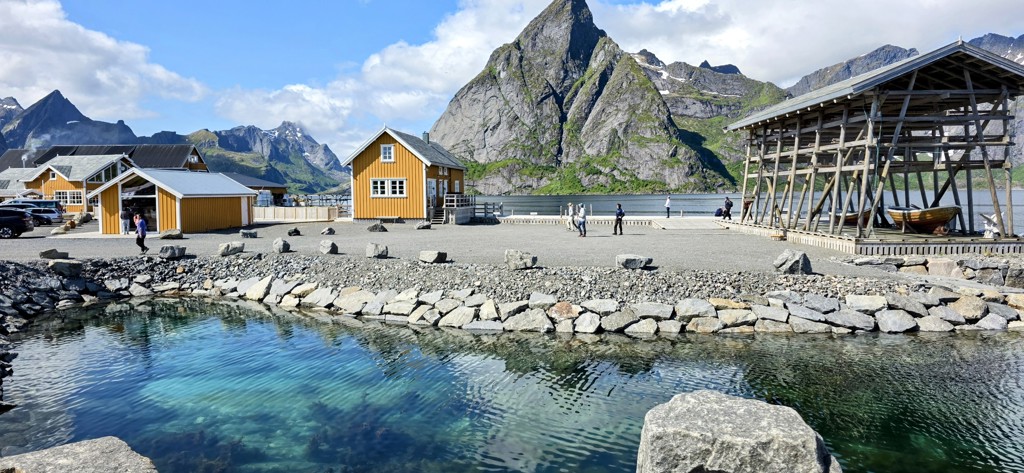Kleurrijke vissershuisjes aan een fjord met bergen op de achtergrond, tijdens een groepsrondreis Noorwegen.