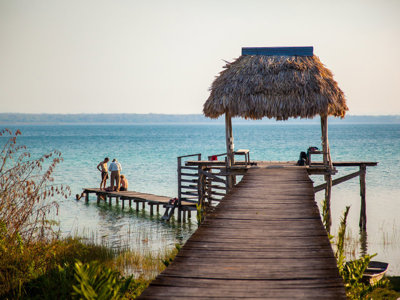 Houten steiger met rieten afdak aan het meer van Petén Itzá in Guatemala.