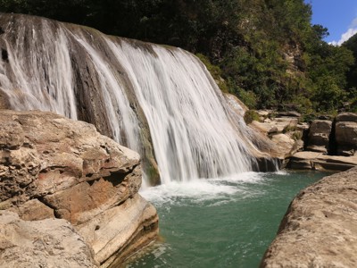 Waterval die over rotsen stroomt in een groene kloof op Timor, Sumba en Bali-route (22 dagen).