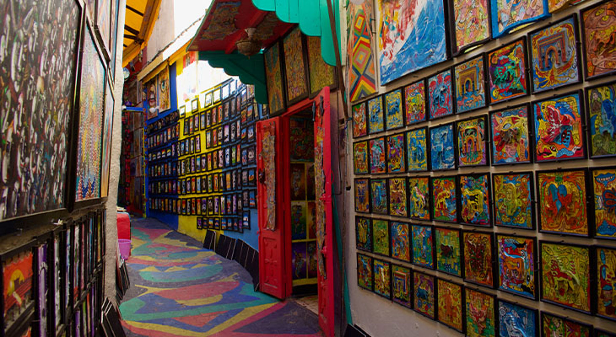 Steden Marokko Kleurrijke straat met muurschilderingen en kunstwerken in een openluchtgalerie.