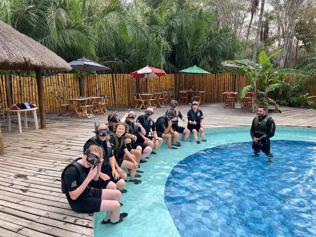 Gezin in wetsuits en snorkelmaskers klaar voor een duikactiviteit tijdens familiereis Argentinië en Brazilië.