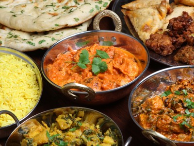 Indiase curry’s met naan, rijst en snacks, geserveerd in metalen schaaltjes tijdens Route Orissa, 23 dagen.