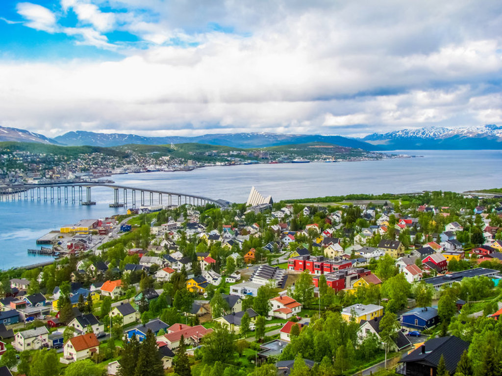 Uitzicht op Tromsø met de Tromsøbrug, kleurrijke huizen en fjordlandschap in Noorwegen.
