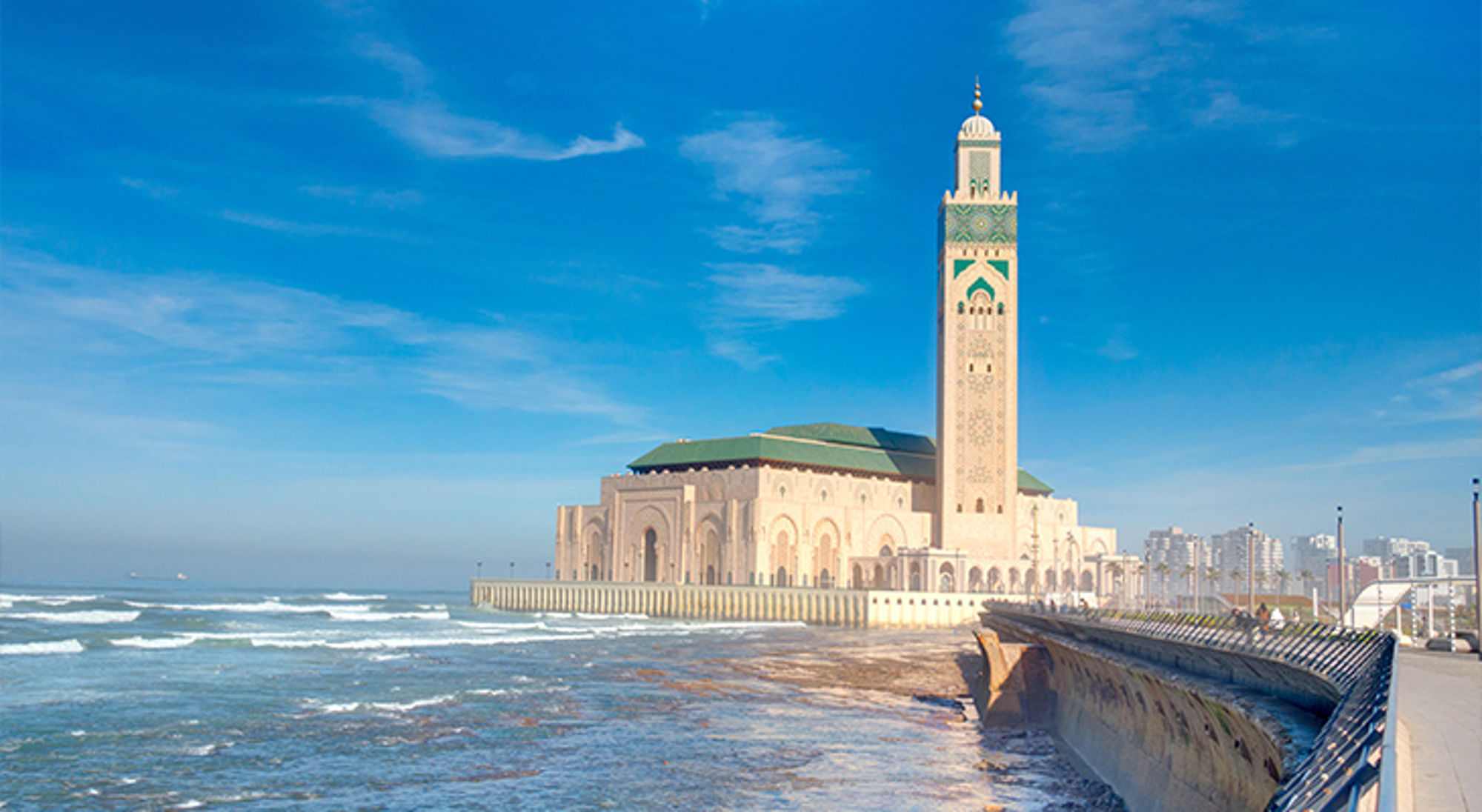 Hassan II moskee Marokko Hassan II-moskee aan de kust van Casablanca met hoge minaret en boulevard langs de Atlantische Oceaan.