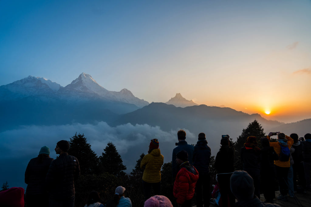 Groep reizigers kijkt naar zonsopkomst boven de Himalaya in Nepal tijdens een 22-35ers reis.
