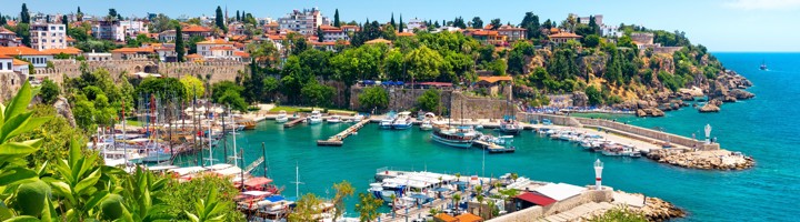 Uitzicht op de haven en oude stad Kaleici in Antalya, met jachten, stadsmuur en rode daken aan zee.