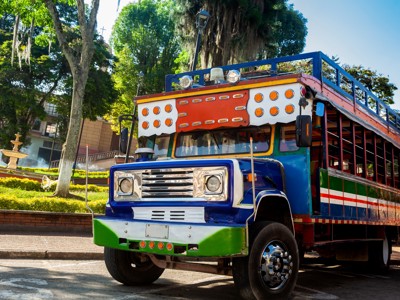 Kleurrijke chiva-bus op een plein in Colombia, onderdeel van de route Colombia.