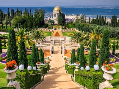 Baha’i-tuinen in Haifa met de gouden koepel van het Baha’i-heiligdom en uitzicht op de Middellandse Zee.