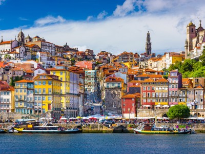 Kleurrijke gevels aan de Ribeira in Porto met traditionele boten op de Douro-rivier.