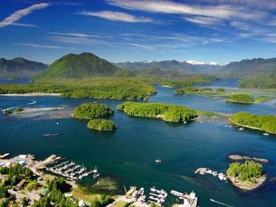 Uitzicht op de kust bij Tofino met groene eilanden, bergen en helderblauw water tijdens Route Canada.