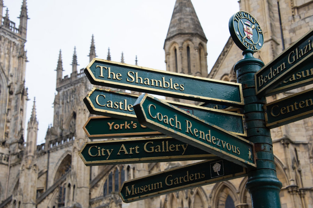 Wegwijzers naar The Shambles en Castle in York, Verenigd Koninkrijk, met York Minster op de achtergrond.