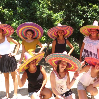 Groep reizigers met kleurrijke sombrero’s tijdens een familiereis Mexico.