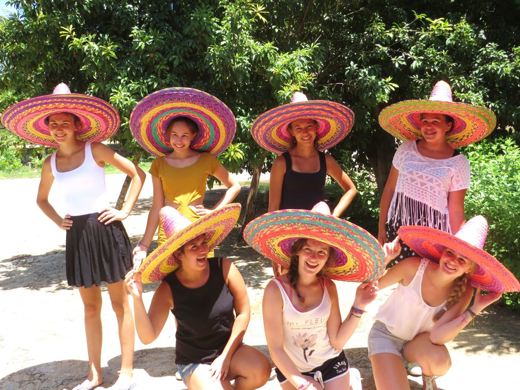 Groep reizigers met kleurrijke sombrero’s tijdens een familiereis Mexico.