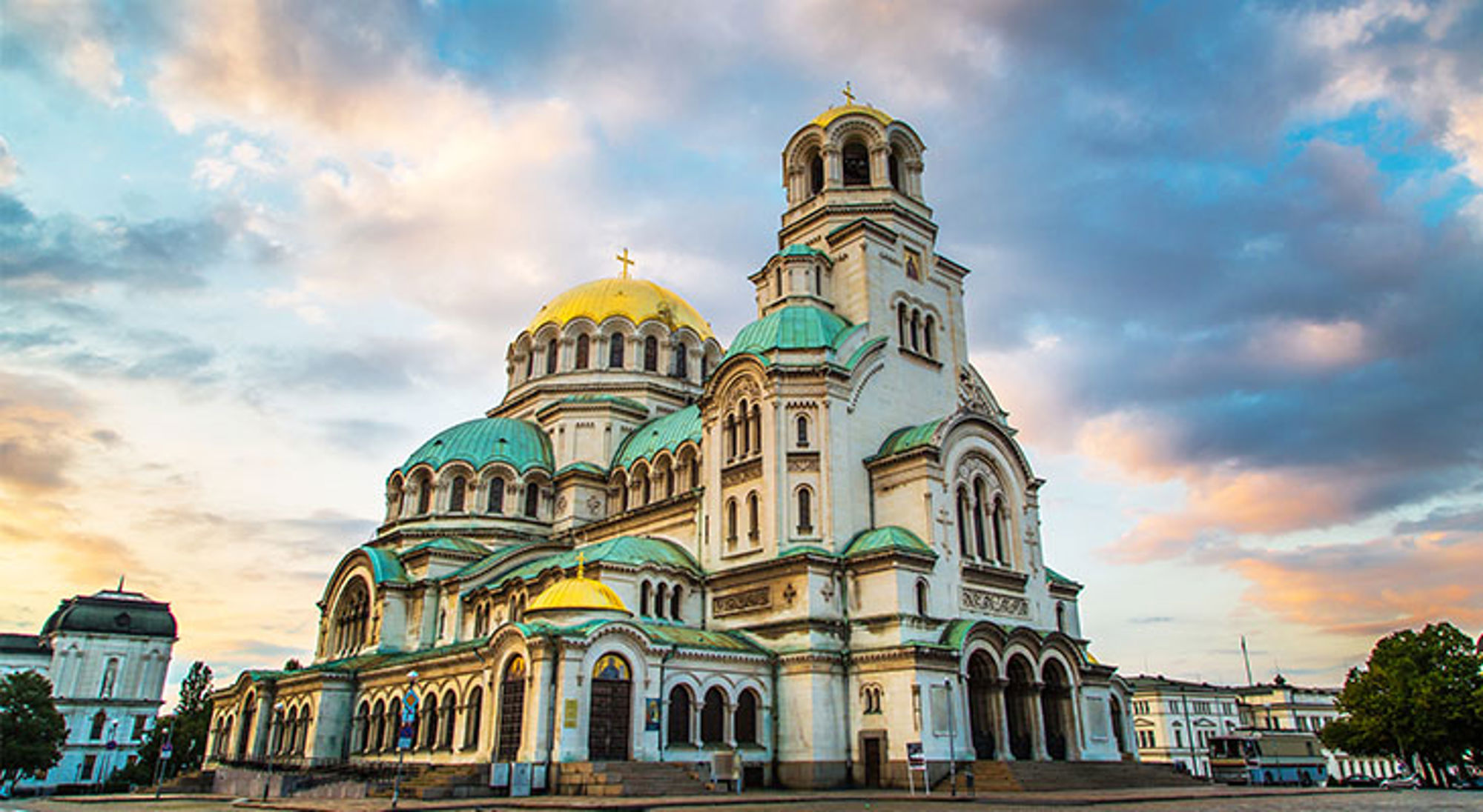 Single reis Bulgarije Alexander Nevski-kathedraal in Sofia met gouden koepels onder een kleurrijke avondlucht.