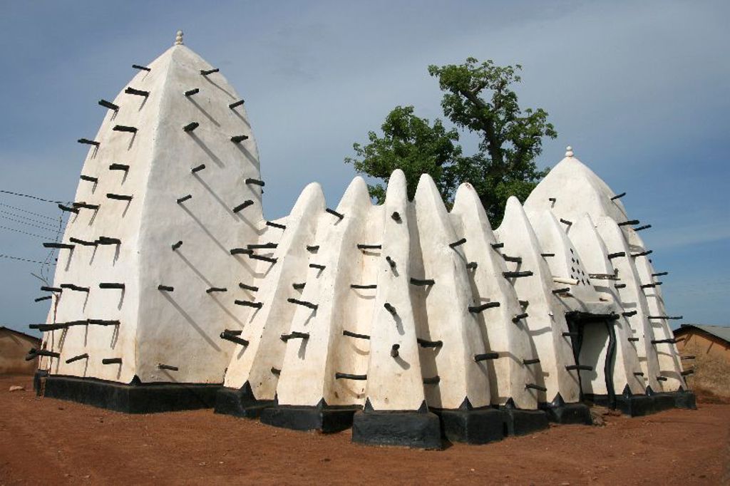 Traditionele lemen moskee met witte torens en houten balken in Ghana, Togo en Benin rondreis.