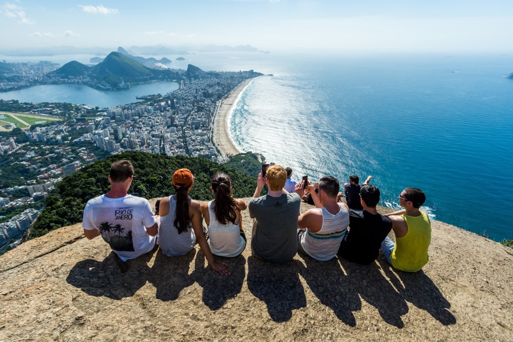 Jongeren kijken uit over Rio de Janeiro en het strand van Copacabana tijdens een 22-35ers reis Brazilië.