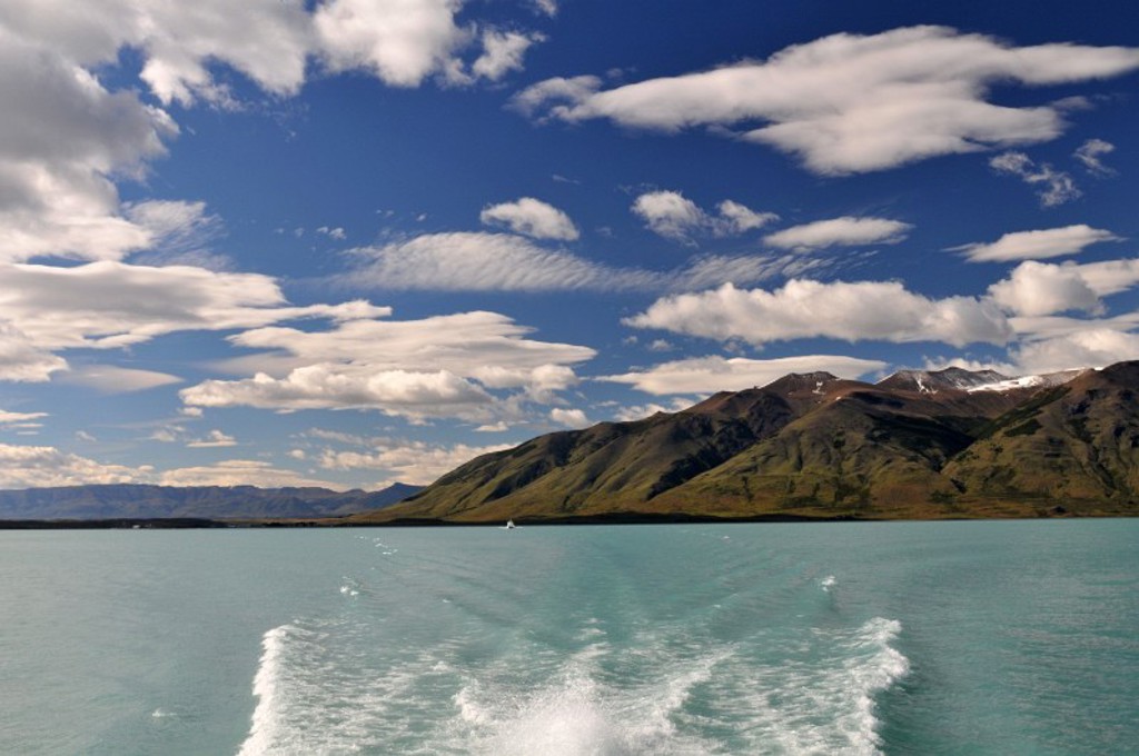 Uitzicht over een turquoise meer met bergketen onder een blauwe lucht, tijdens een groepsrondreis in Argentinië.