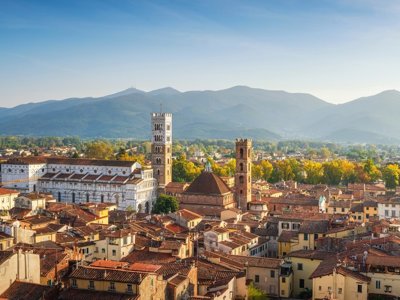 Fietsers op een landweg tussen cipressen en heuvels in Toscane.