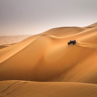 4x4 rijdt over hoge zandduinen tijdens groepsrondreis Oman en Dubai.