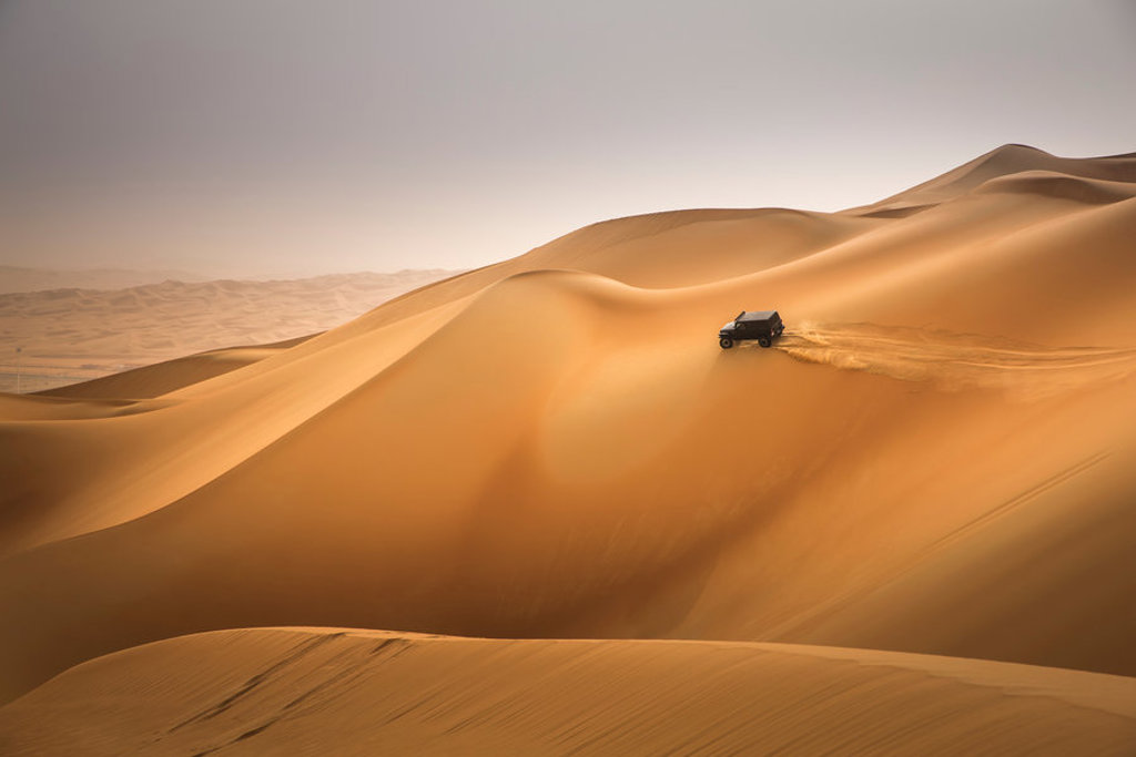 4x4 rijdt over hoge zandduinen tijdens groepsrondreis Oman en Dubai.