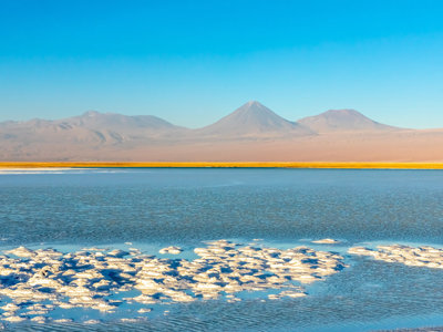 Lagune in de Atacama-woestijn met zoutkristallen en vulkanen op de achtergrond, route Bolivia en Chili.