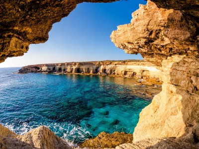 Rotskust met zeegrotten en helderblauw water op Cyprus tijdens een familiereis.