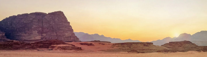 Zonsondergang boven de rotsformaties en zandvlakte van Wadi Rum in Jordanië.