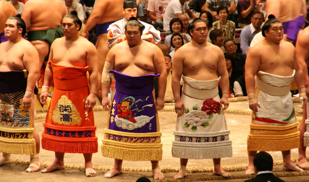 Sumoworstelaars in kleurrijke mawashi in de ring tijdens een sumotoernooi in Japan.