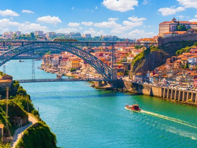 Uitzicht op de Dom Luís I-brug over de Douro in Porto, met kleurrijke huizen langs de rivier.