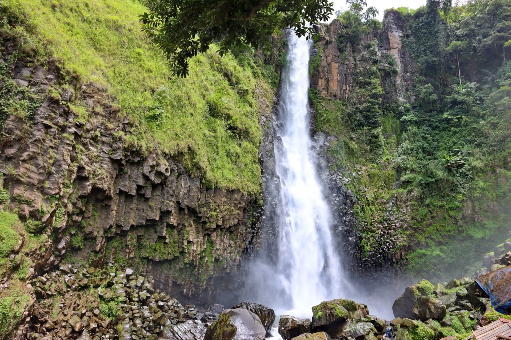 Hoge waterval tussen groene rotswanden op Sulawesi, Indonesië.