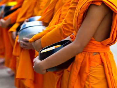 Boeddhistische monniken in oranje gewaden met offerkommen tijdens de Thailand-rondreis van 22 dagen.