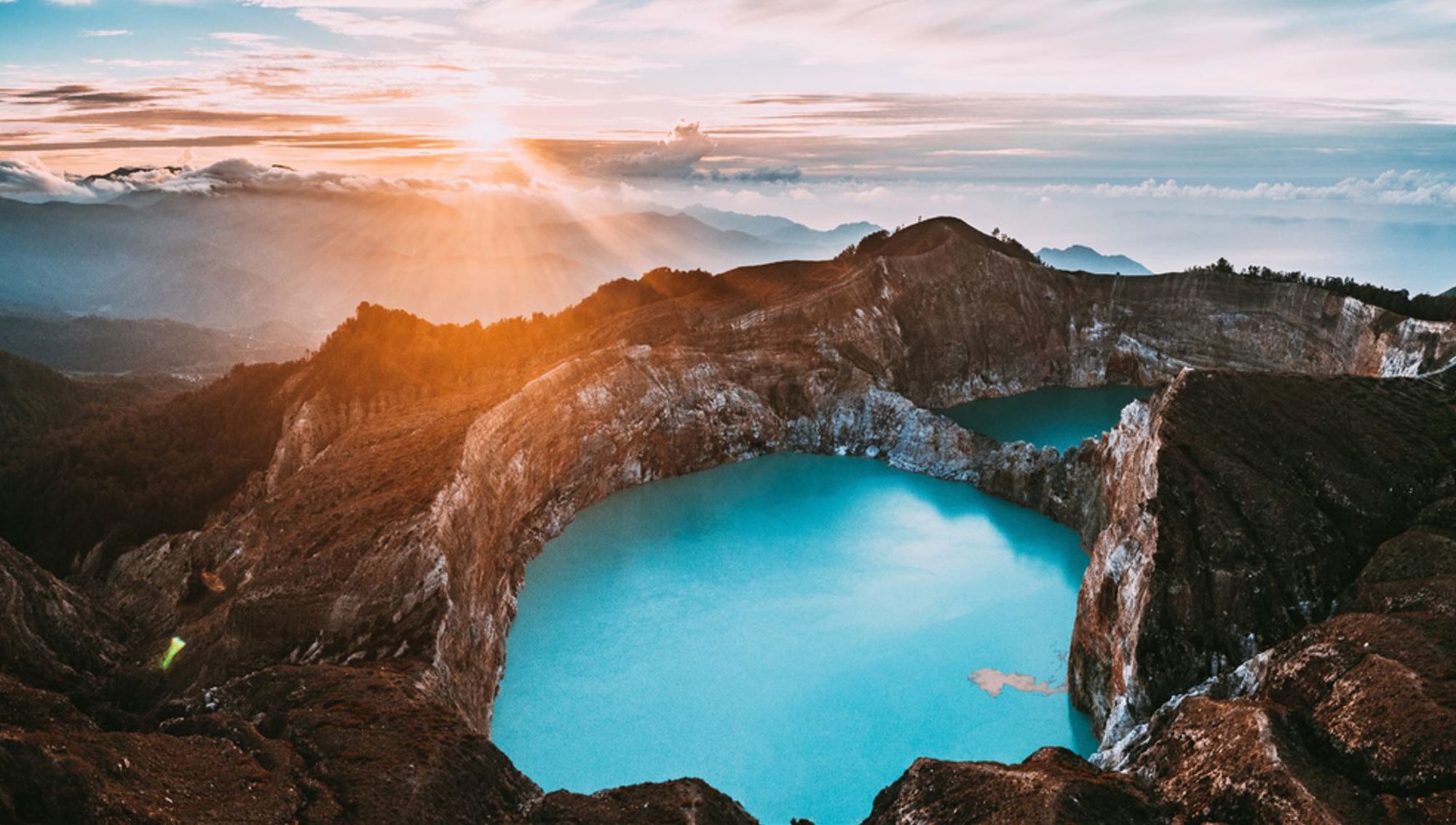 Zonsopkomst bij de Kelimutu-kratermeren met felblauw water op Flores, Indonesië.