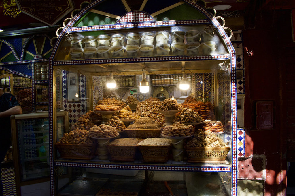 Marokkaanse patisserie met stapels koekjes en noten in een mozaïek vitrine, tijdens groepsrondreis Marokko Kort.