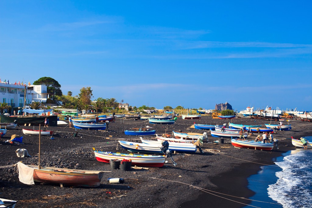 Vissersboten op het zwarte lavazandstrand van Sicilië aan de Tyrreense Zee.