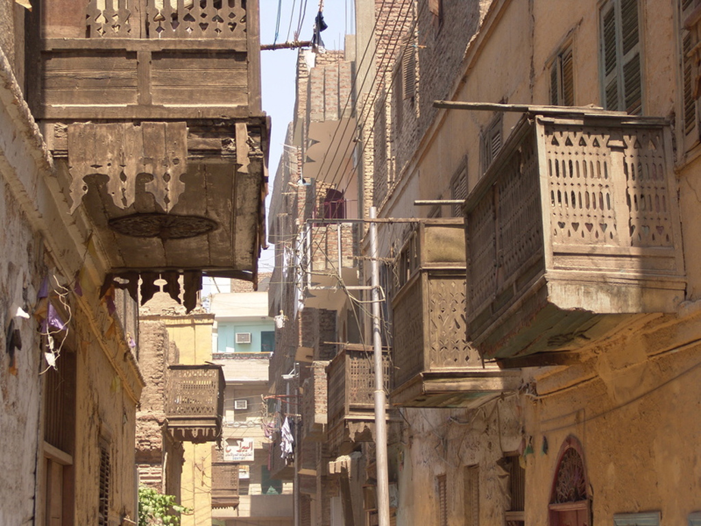Smalle straat in Egypte met traditionele houten balkonnetjes en oude gevels.