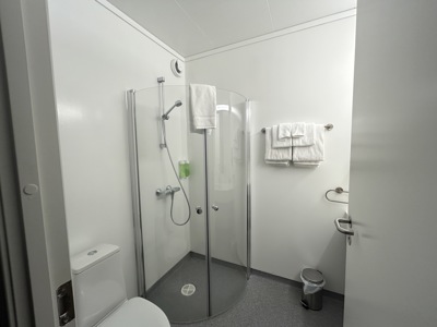 Badkamer in Fosshotel Nupar met douchecabine, toilet en handdoeken.