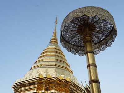 Gouden tempelstupa met sierlijke parasol bij een boeddhistisch tempelcomplex in Thailand.