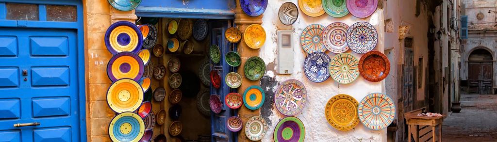 Kleurrijke Marokkaanse keramiekschalen aan een winkelgevel in een medina, tijdens groepsrondreis Marokko Chill & Adventure.