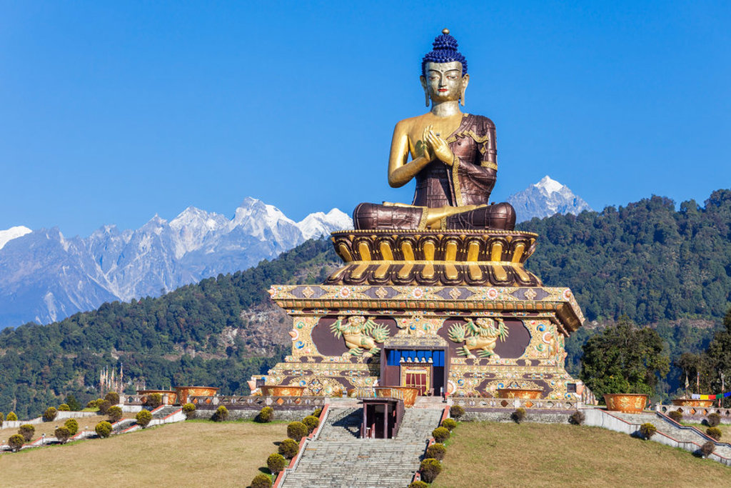 Groot Boeddhabeeld in Sikkim met besneeuwde Himalaya-bergen op de achtergrond.