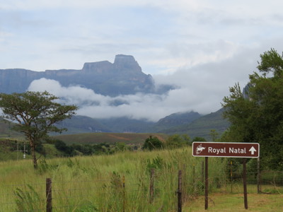 Wegwijzer naar Royal Natal met berglandschap en laaghangende wolken op de route Kaapstad–Johannesburg.