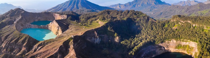 Uitzicht op de kratermeren van Kelimutu op Flores, Indonesië, met turquoise en donker meer tussen vulkanische bergen.