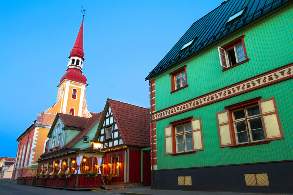 Kleurrijke straat in Tallinn met historische huizen en kerktoren, Estland.
