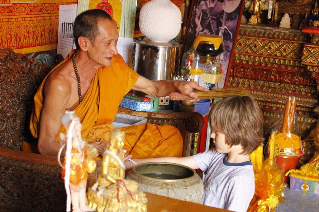 Boeddhistische monnik zegent een kind in een Thaise tempel tijdens familiereis Thailand Comfort-Plus.