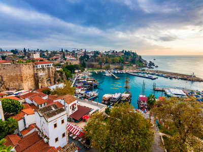 Haven van Antalya met jachten, oude stadsmuren en rode daken aan de Turkse Rivièra bij zonsondergang.