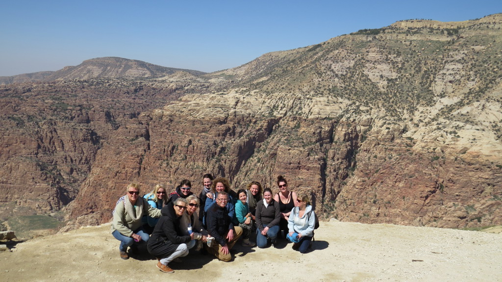 Groepsrondreis Israël en Jordanië: reizigers poseren bij een uitzichtpunt met rotsachtige kloof op de achtergrond.