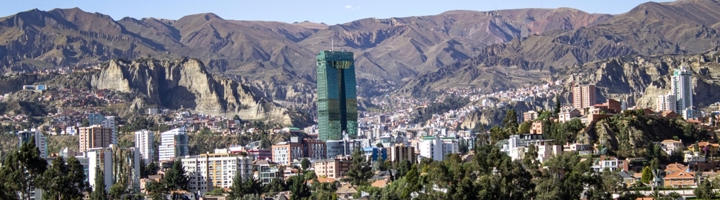 Panorama van La Paz met de groene Torre Ejecutiva en de Andesbergen op de achtergrond.