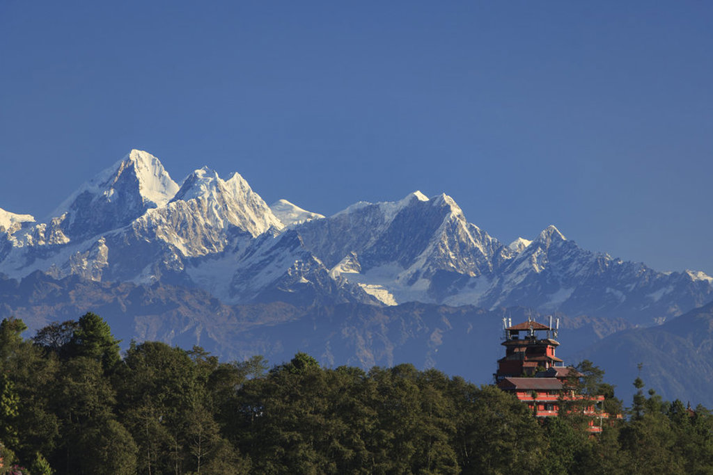 Himalaya-bergen met besneeuwde toppen en een tempel tussen de bomen tijdens een familiereis in Nepal.