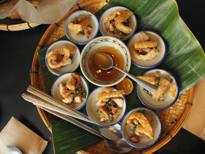 Vietnamese hapjes met krokante toppings en dipsaus op een bamboeschaal, Route Vietnam dag 10.